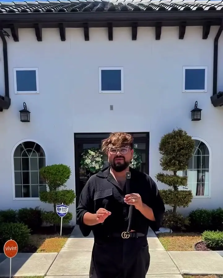 JoeJoe, founder, standing at the arched entrance of the white Spanish-style building on Jackson Rd